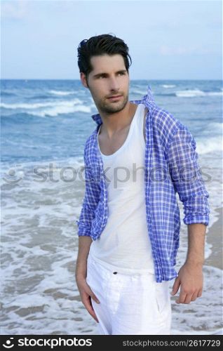 Mediterranean latin young man on summer blue beach wakling relaxed
