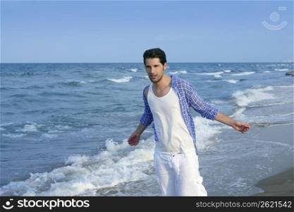 Mediterranean latin young man on summer blue beach wakling relaxed