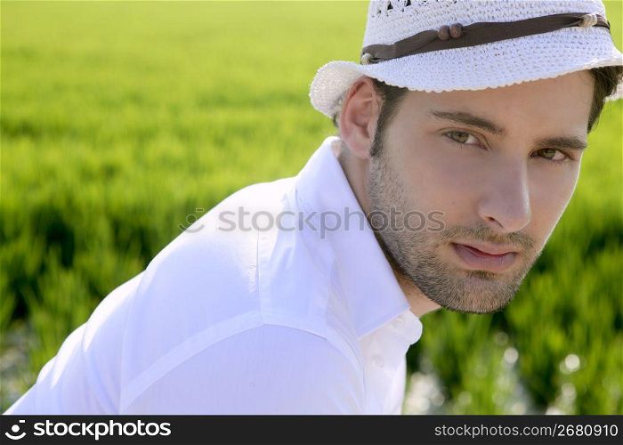 Mediterranean man portrait white hat in green meadow rice field