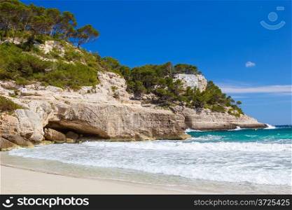 Mediterranean sea cliffs at Cala Mitjana beach at Menorca island, Spain.