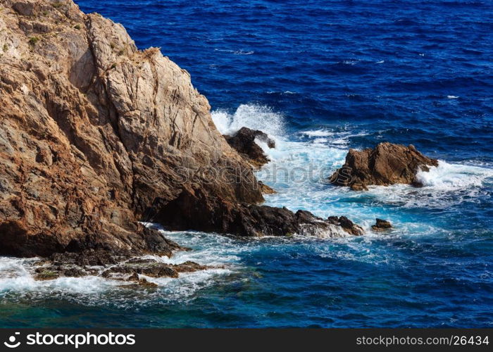 Mediterranean sea summer rocky coast view and fishing rods on cliff below (Costa Blanca, Spain).