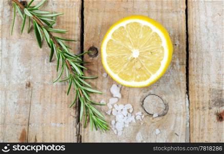 Mediterranean spices - rosemary, lemon, sea salt on wooden background