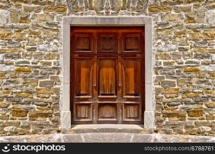 Mediterranean style wooden door on stone wall, architecture detail view