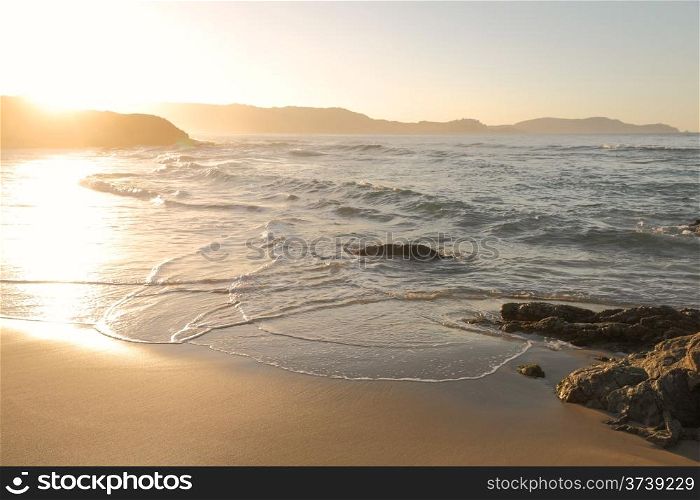 Mediterranean waves washing onto the golden sand at Plage de Petra Muna near Calvi in Corsica