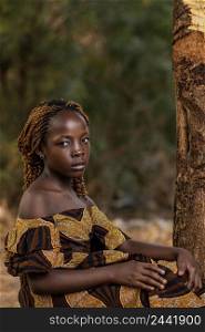 medium shot african girl posing near tree