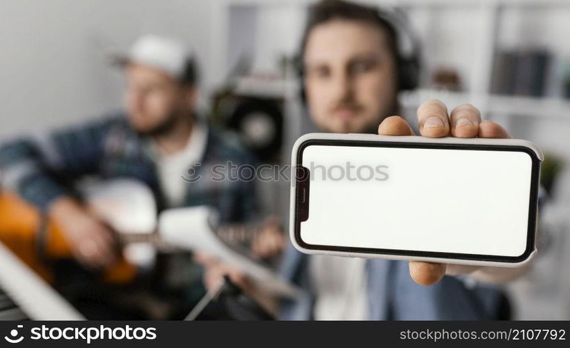 medium shot blurry man holding smartphone