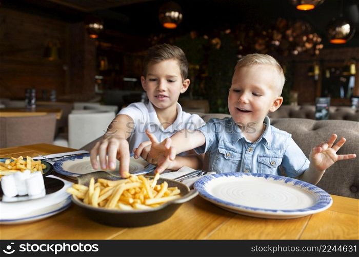 medium shot boys eating fries