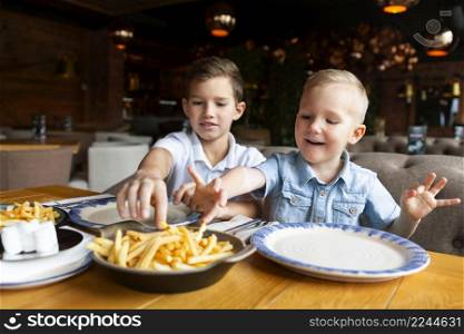 medium shot boys eating fries