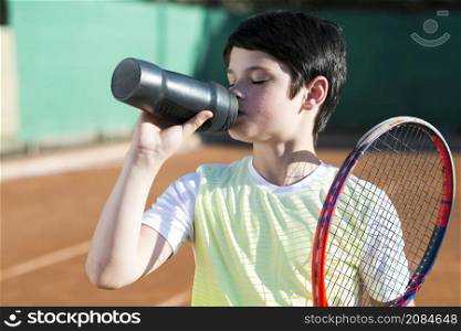 medium shot brunette kid drinking water with racket shoulder