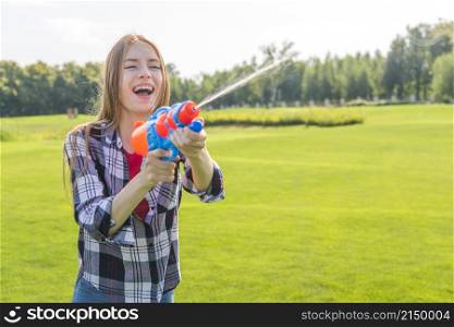 medium shot cheerful girl playing with water gun