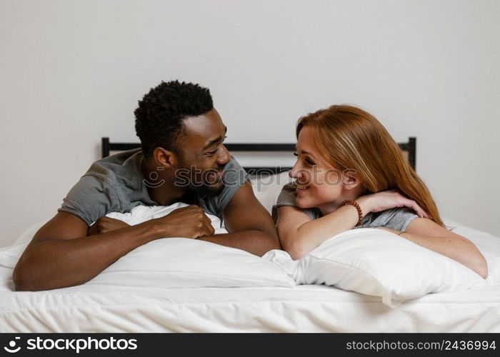 medium shot couple laying bed