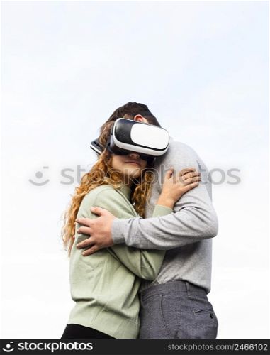 medium shot couple with vr glasses hugging