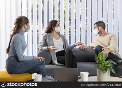 medium shot coworkers couch with masks