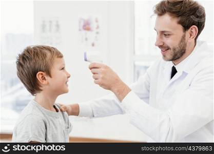 medium shot doctor checking kid temperature