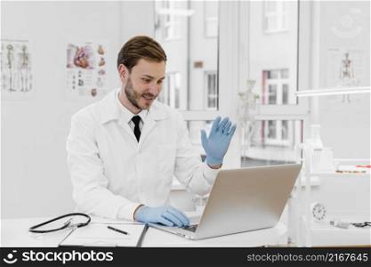 medium shot doctor working laptop