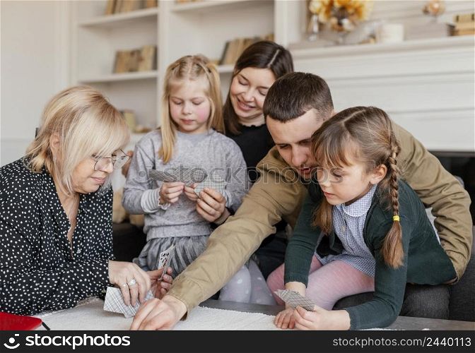 medium shot family playing cards