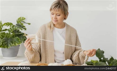 medium shot focused woman knitting