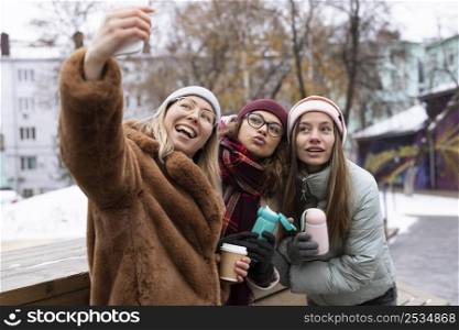 medium shot friends taking selfies