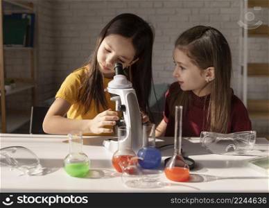 medium shot girl looking through microscope