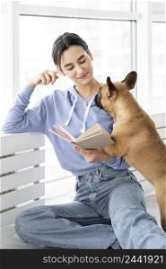 medium shot girl reading near dog