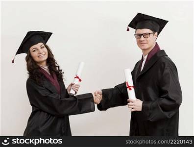 medium shot graduates shaking hands