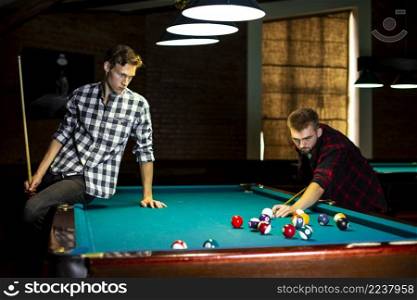 medium shot guy sitting pool table
