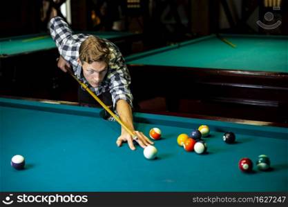 medium shot guy with pool cue billiard table