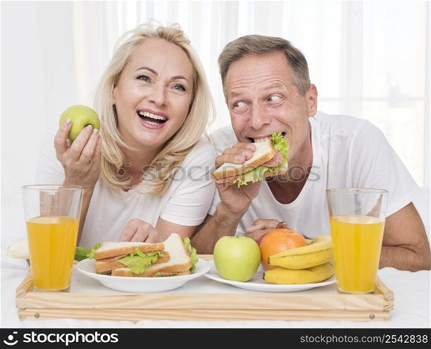 medium shot happy couple eating healthy together