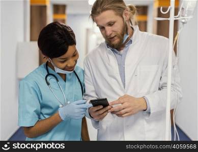 medium shot health workers with smartphone