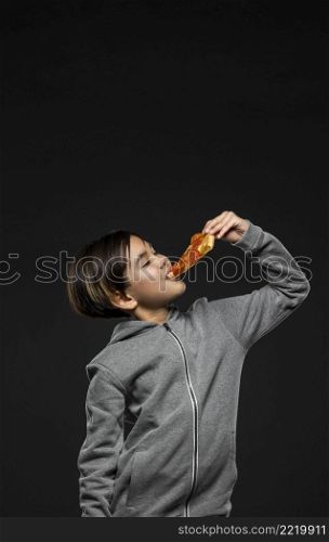 medium shot kid eating pizza with copy space