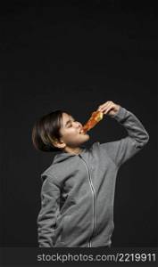 medium shot kid eating pizza with copy space