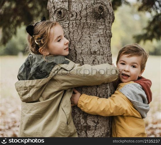 medium shot kids hugging tree