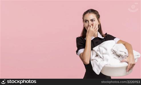 medium shot maid holding smelly laundry basket
