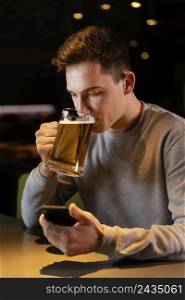 medium shot man drinking beer pub