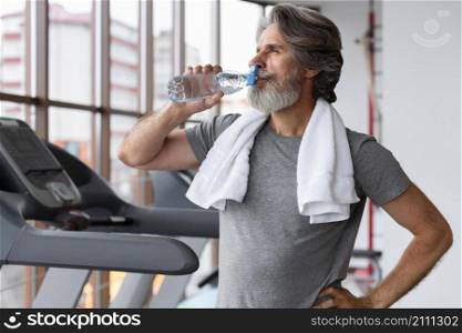 medium shot man drinking water gym