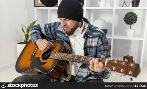 medium shot man holding guitar