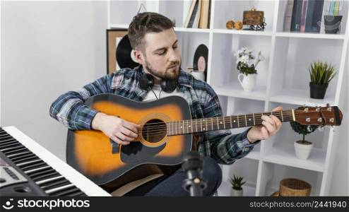 medium shot man playing guitar