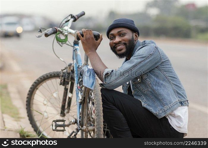 medium shot man posing near bicycle