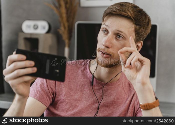medium shot man streaming with phone