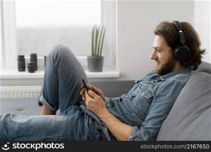 medium shot man with headphones couch