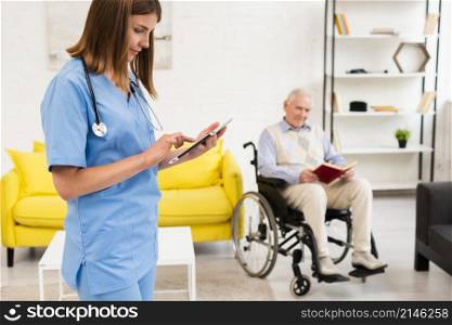 medium shot nurse checking her tablet