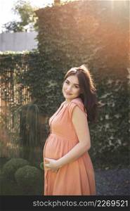 medium shot pregnant woman posing outdoors