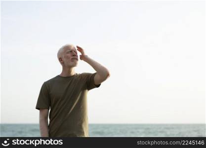 medium shot senior man posing seaside