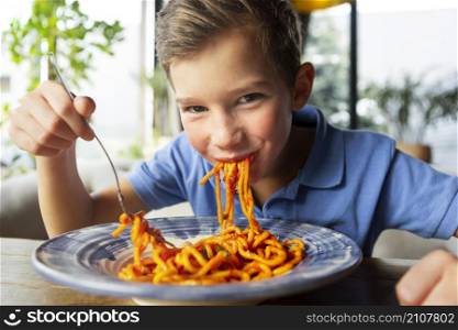 medium shot smiley boy eating spaghetti