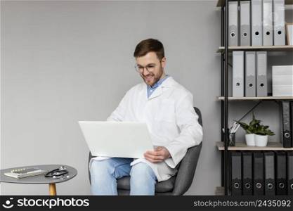 medium shot smiley doctor working with laptop
