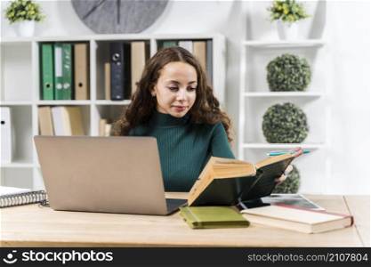 medium shot smiley girl studying with dictionary laptop