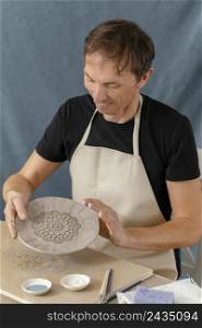 medium shot smiley man doing pottery