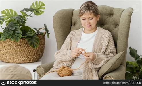medium shot smiley woman knitting