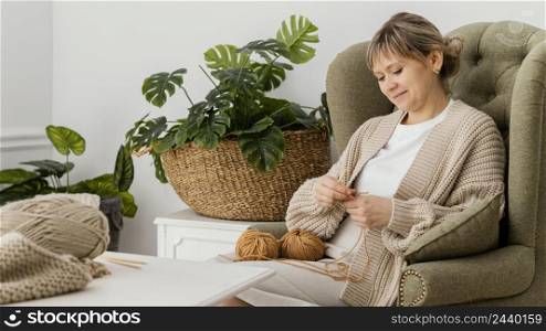 medium shot smiley woman knitting armchair