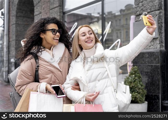 medium shot smiley women taking selfie
